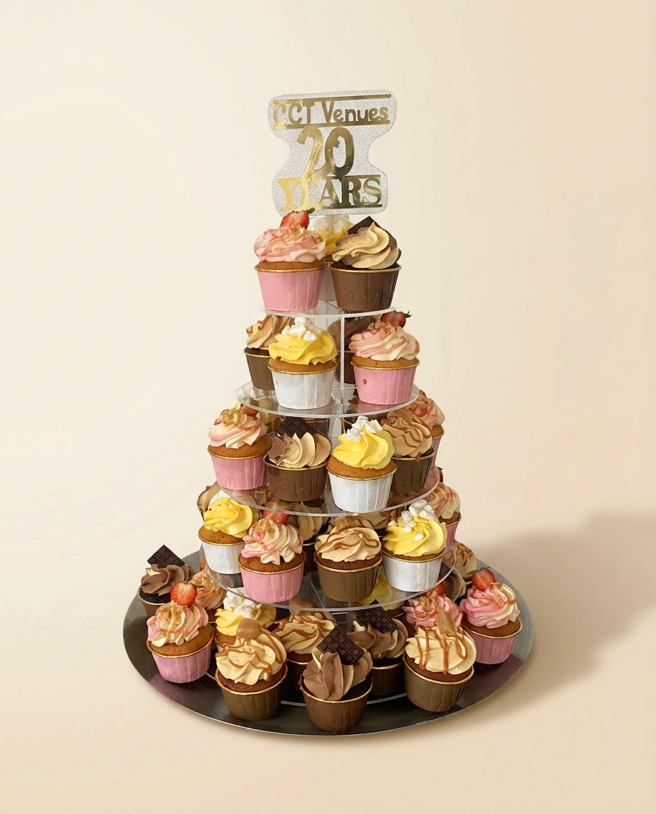 Five-tiered cupcake stand with variously decorated cupcakes on a beige background