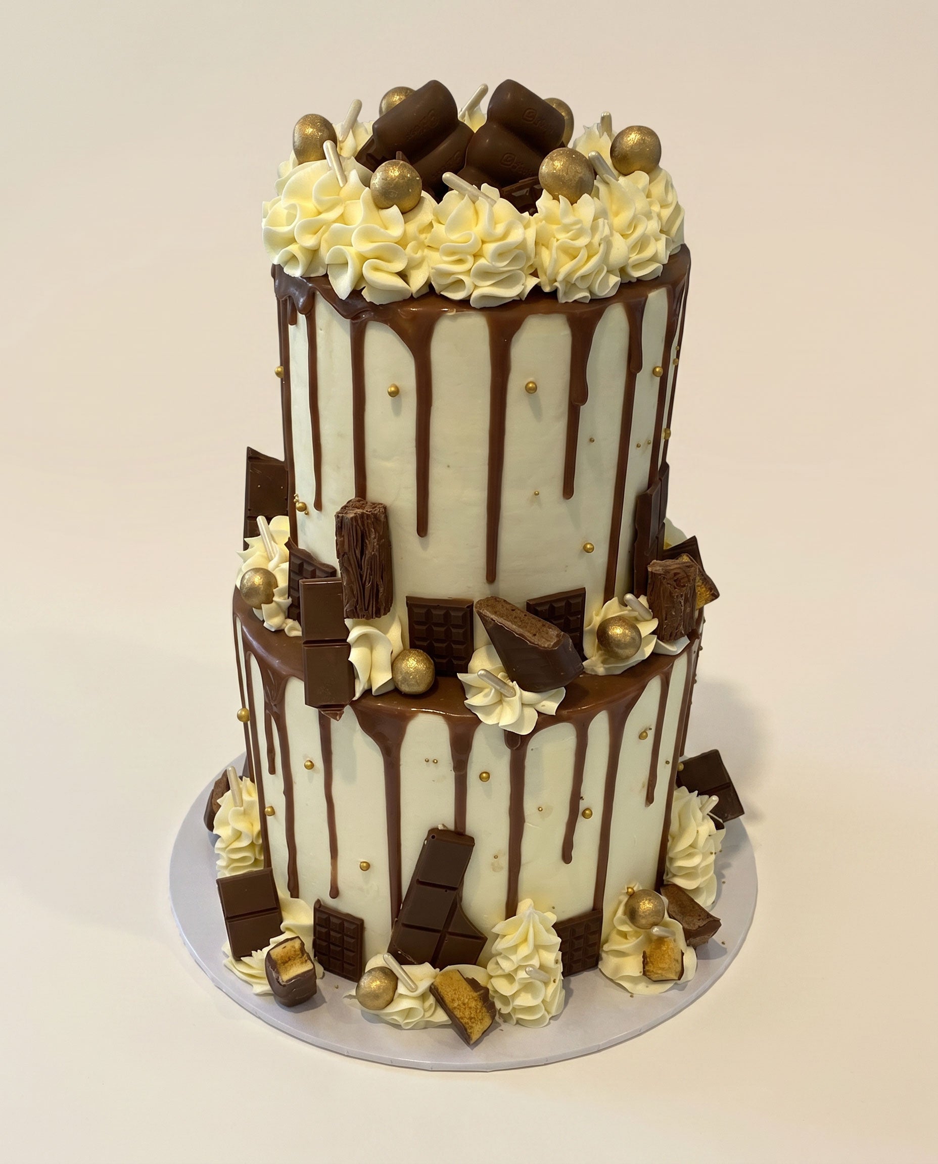 Classic chocolate bar two-tier drip cake with chocolate drip finish and bar toppings, handmade by Daisy Mud Pie in Brentwood, Essex