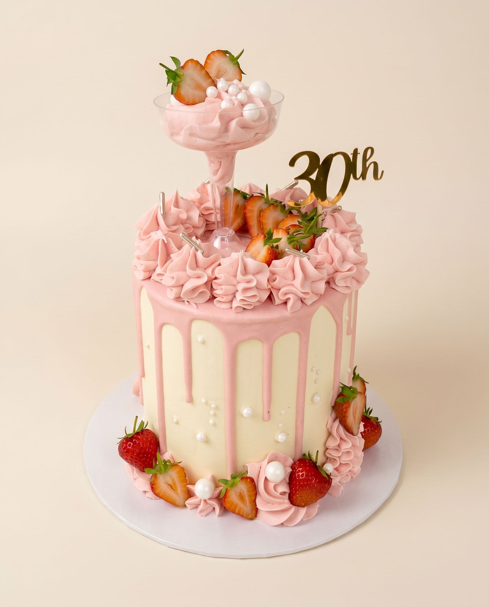 Strawberry martini drip cake topped with fresh strawberries and a cocktail-inspired finish, handmade by Daisy Mud Pie in Brentwood, Essex