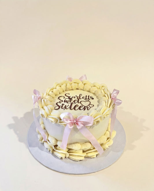 Buttercream celebration cake decorated with pink bows and a sweet sixteen topper, handmade by Daisy Mud Pie in Brentwood, Essex