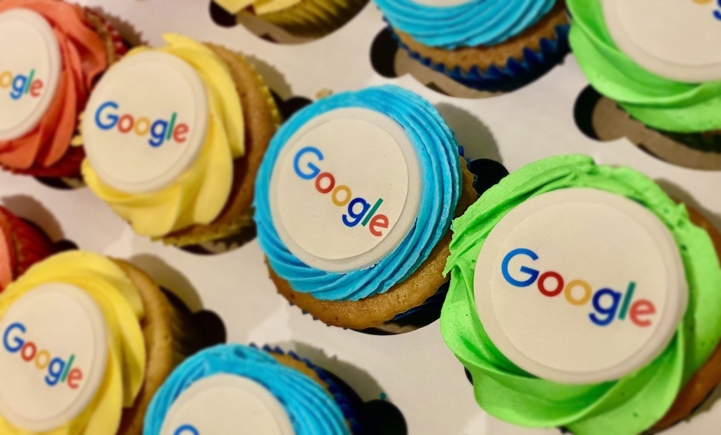 Custom logo Cupcakes with Google logo on a white surface